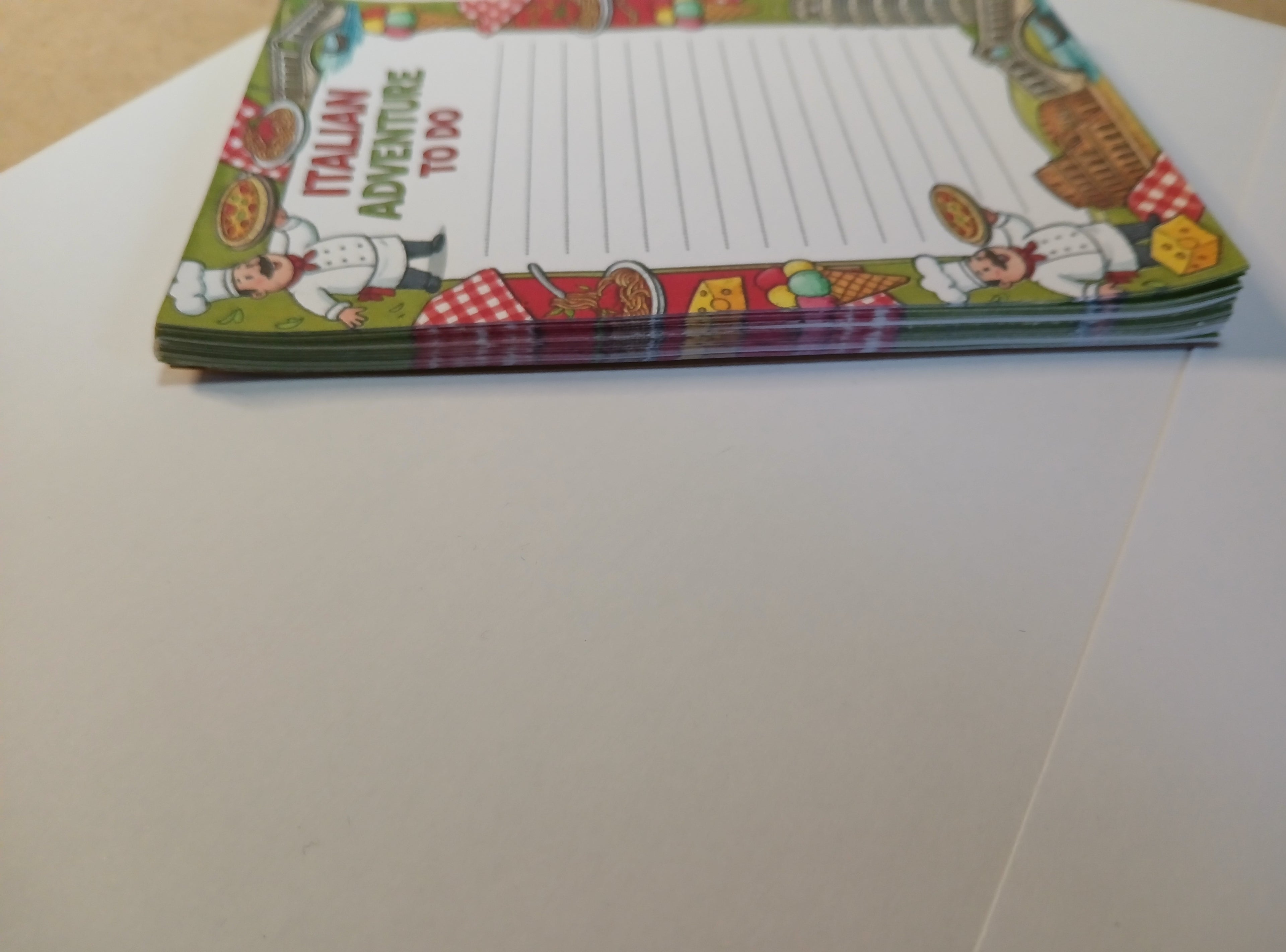 Colorful notepad with Italian-themed design on a white surface